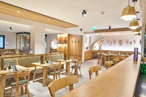 a restaurant with wooden tables and chairs and a bar at Gasthof Maxlhaid in Wels