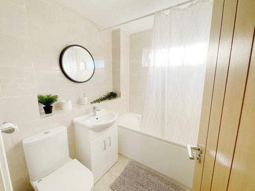 a white bathroom with a toilet and a tub and a sink at Oxford city centre house/walkable to University in Oxford