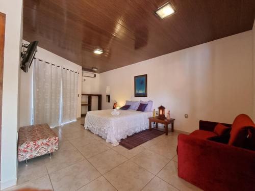 a large bedroom with a bed and a couch at Pousada Ikabana in Pirenópolis