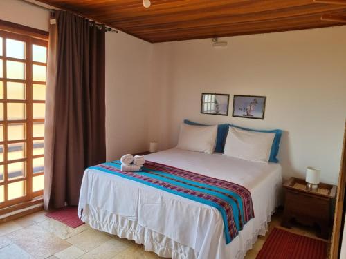 a bedroom with a bed in a room with a window at Pousada Ikabana in Pirenópolis