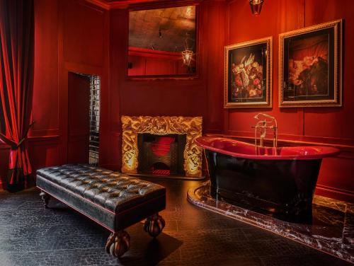 a red bathroom with a tub and a fireplace at Chateau Denmark in London