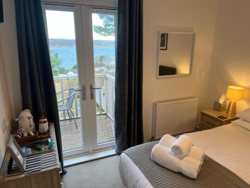 a bedroom with a bed with a view of the ocean at Loch Eyre House in Portree