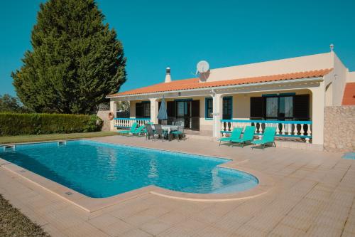 a villa with a swimming pool in front of a house at Casa Joaquina in Carvoeiro