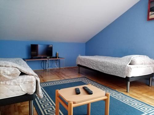 Habitación con 2 camas, TV y mesa. en Apartments Dobra Vila, en Zlatibor