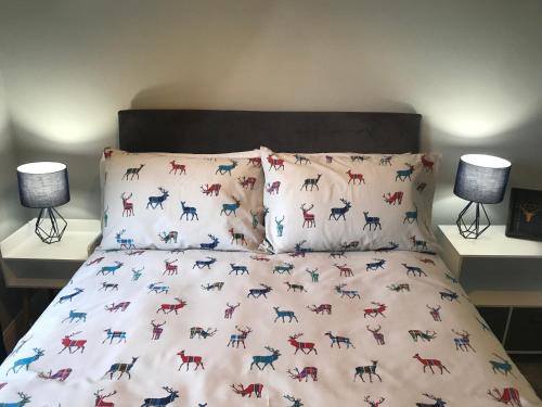 a bed with a comforter with horses on it at Fantastic 2 bed flat in Dunblane High Street in Dunblane