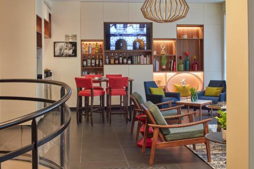 a bar with red and blue chairs and tables at Hotel Atmospheres in Paris