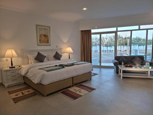 ディバ・アル・ヒスンにあるHoliday Beach Resortのベッドルーム(大型ベッド1台付)、リビングルームが備わります。