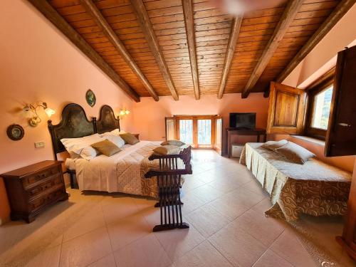 a large bedroom with two beds and a wooden ceiling at VILLA PANORAMICA DELL'ETNA in SantʼAlfio