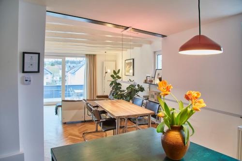 een eetkamer met een tafel en een vaas met bloemen bij Klimatisierte Wohnung mit großer Terrasse in Deidesheim