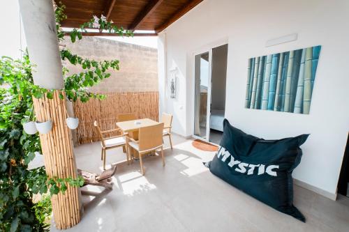 a living room with a table and a chair at Sunset Wave - STAGNONE KITESURF VILLAGE in Birgi Vecchi