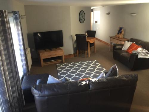 a living room with a couch and a tv at Stylish Historic Apartment - Sleeps 3 & Parking in Norwich