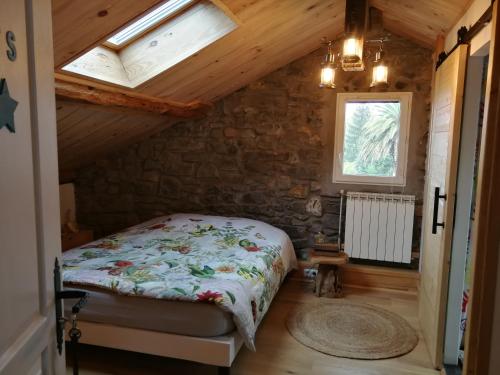 um quarto com uma cama num sótão com uma janela em Chambres d'hôtes "HOR DAGO" près de la gare d'Hendaye avec le petit-déjeuner em Hendaye
