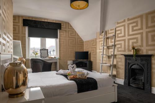 a bedroom with a bed with a fireplace and a desk at The North Shore in Llandudno