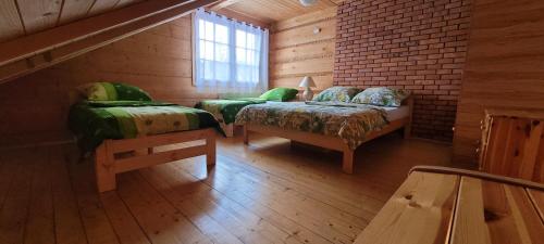 a room with two beds in a wooden cabin at ChatauBrata in Krynica Zdrój