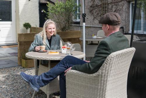 a man and a woman sitting at a table at Tudor Lodge in Porthmadog