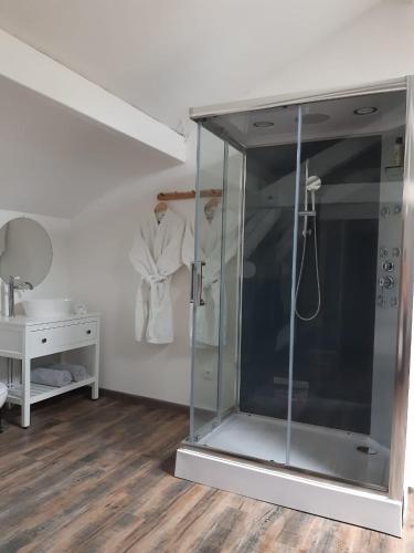 a glass shower stall in a room with a table at Jacuzzi, Arcade et Repas compris in Soulosse-sous-Saint-Élophe