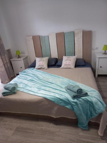 een slaapkamer met een groot bed met blauwe lakens en kussens bij Casa mary in Costa de Antigua