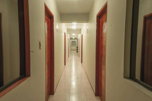 a hallway with many doors and a long corridor at Hotel Residencial San Isidro in Hualmay