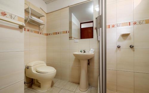 a bathroom with a toilet and a sink at Hotel Rio Blanco in Piura