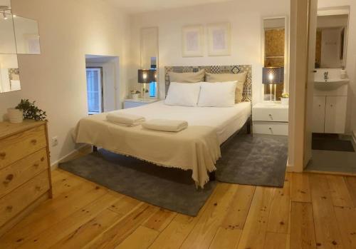 una camera con un grande letto e un bagno di Historical Bica - 3 Bedroom Apartment a Lisbona