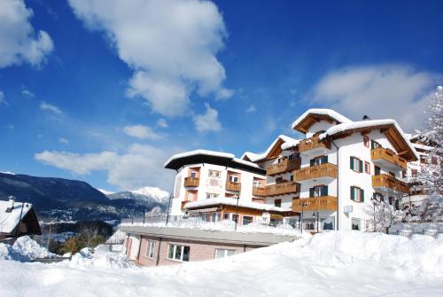 a building covered in snow on a mountain at La Montanina Hotel in Val di Non in Malosco