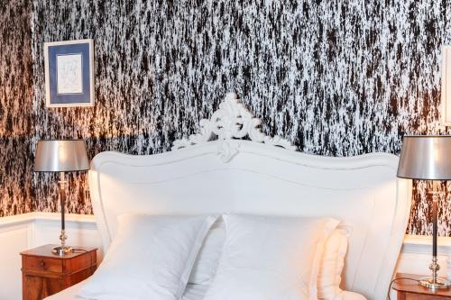 a bedroom with a white bed with two lamps at La Maison D'Hôtes Nantes Centre in Nantes