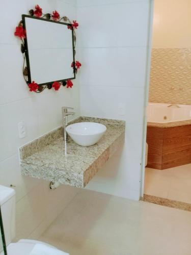 a bathroom with a sink and a mirror at Hotel Pousada Riacho da Areia in Águas de Lindóia