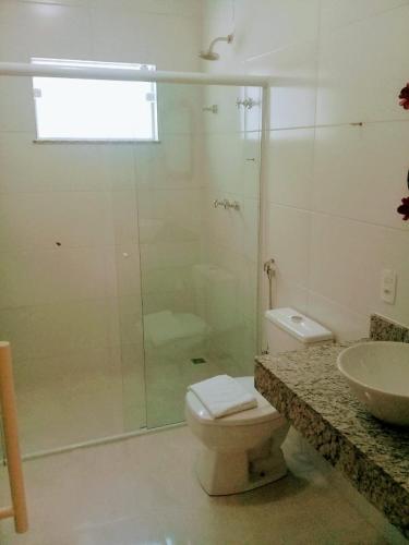 a bathroom with a shower and a toilet and a sink at Hotel Pousada Riacho da Areia in Águas de Lindóia