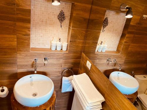 a bathroom with two sinks and two mirrors at Casa Pisica Noastra in Breaza
