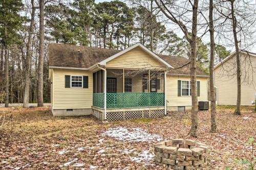 a yellow house with a tree in the yard at Pool Access and Fire Pit Ocean Pines Retreat! in Ocean Pines