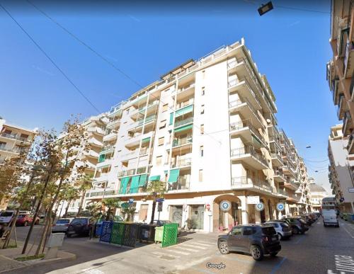 a large white building with cars parked in front of it at Casa Azzurra in Loano