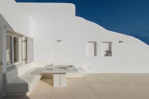 a white room with a bench in the middle at Villa Conza Mykonos in Agios Ioannis Mykonos