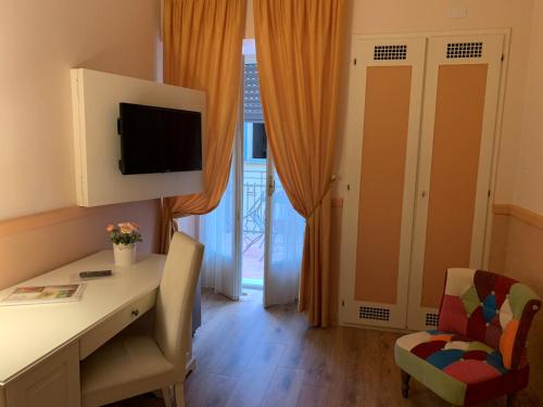 a room with a desk and a chair and a television at Hotel Roma in Bologna