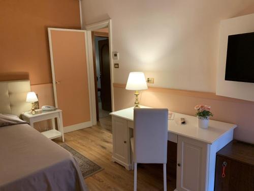a hotel room with a desk and a television at Hotel Roma in Bologna