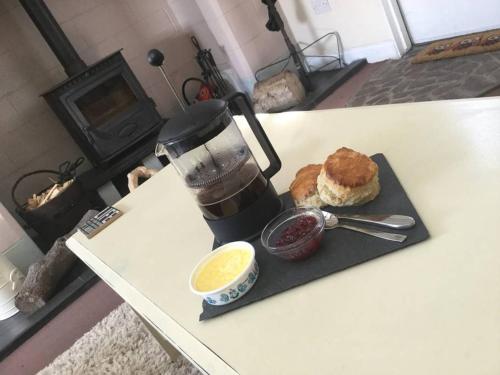uma mesa com um liquidificador, um muffin e uma bebida em The Hermitage em Great Torrington