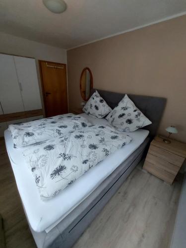 ein Schlafzimmer mit einem Bett mit einer weißen Decke und Kissen in der Unterkunft Ferienwohnung See & Bergblick in Winterberg