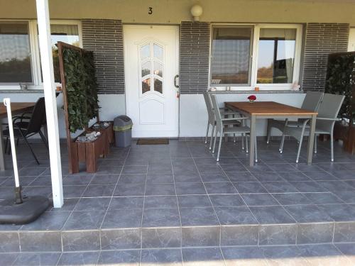 a patio with a table and chairs and a white door at Ruegen Fewo 168 in Zudar