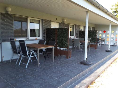 a patio with tables and chairs on a house at Ruegen Fewo 168 in Zudar