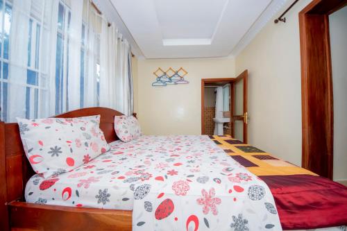 a bedroom with a bed with red and white blankets and pillows at Fleur Guest House in Kigali