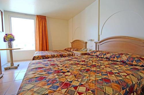 a hotel room with two beds with a colorful quilt at Aranzazu Eco in Guadalajara