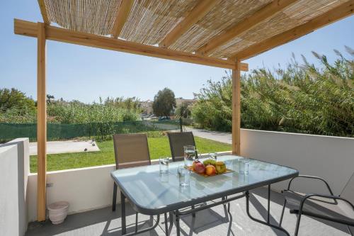 a table with a bowl of fruit on a patio at SEA BREEZE APARTMENTS in Kolymvari