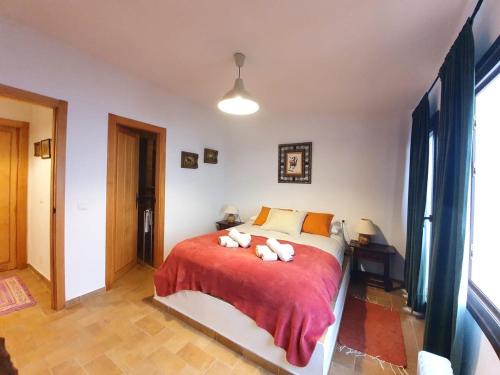 ein Schlafzimmer mit einem Bett mit zwei ausgestopften Tieren darauf in der Unterkunft Spanish Townhouse in Spa Village/ Casa rural in Carratraca