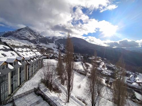 a city with snow covered buildings and a mountain at Apartamentos Ball Benas Edificio Prados de Velarta in Cerler
