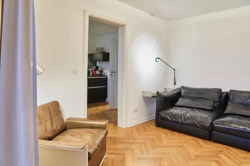 a living room with a couch and a chair at Gemütliche Wohnung mit Balkon in Deidesheim