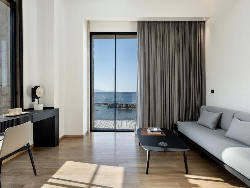 a living room with a couch and a view of the ocean at The Tanneries Hotel & Spa - a Member of Design Hotels in Chania Town