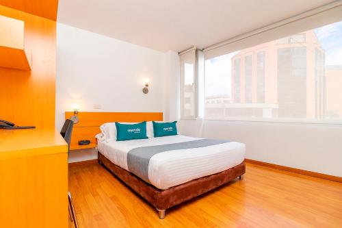 a bedroom with a bed and a large window at Ayenda Abitare 56 in Bogotá