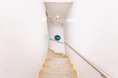 a staircase in a building with a blue sign on the wall at Ayenda Golden Empresarial in Pereira