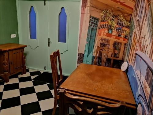 a dining room with a table and a checkered floor at Villa Le Jardin in Oude Pekela