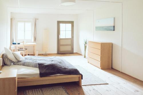 a bedroom with a bed and a dresser in it at Das Detox Almhaus in Pusterwald