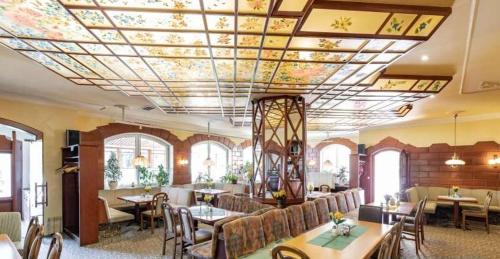 una stanza con tavoli e sedie e un soffitto fiorito di Austria Traveller Hotel Lenzing a Lenzing